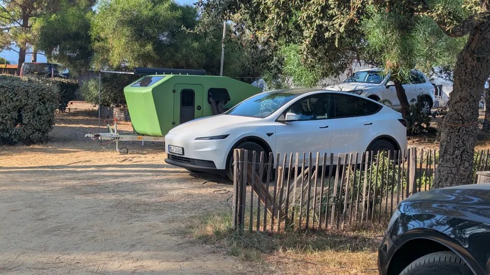 Glide und E-Auto auf einem Campingplatz unter Bäumen
