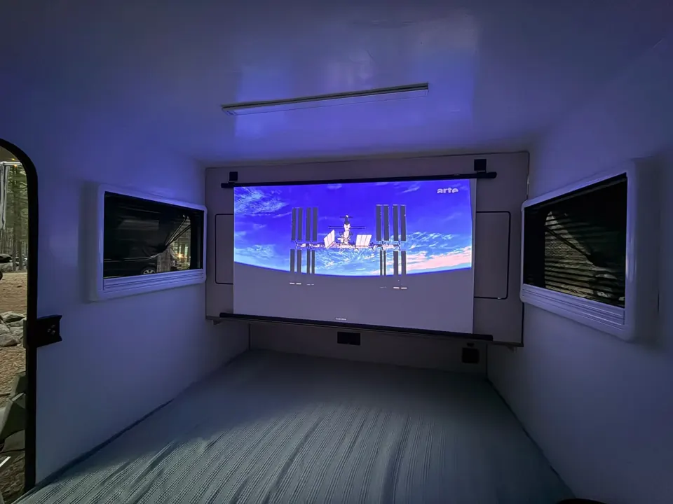 Leinwand mit Projektion im abgedunkelten Schlafraum