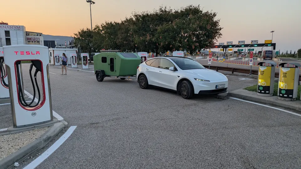 Tesla Model Y mit Glide am Supercharger an der italienischen Autobahn im Abendlicht